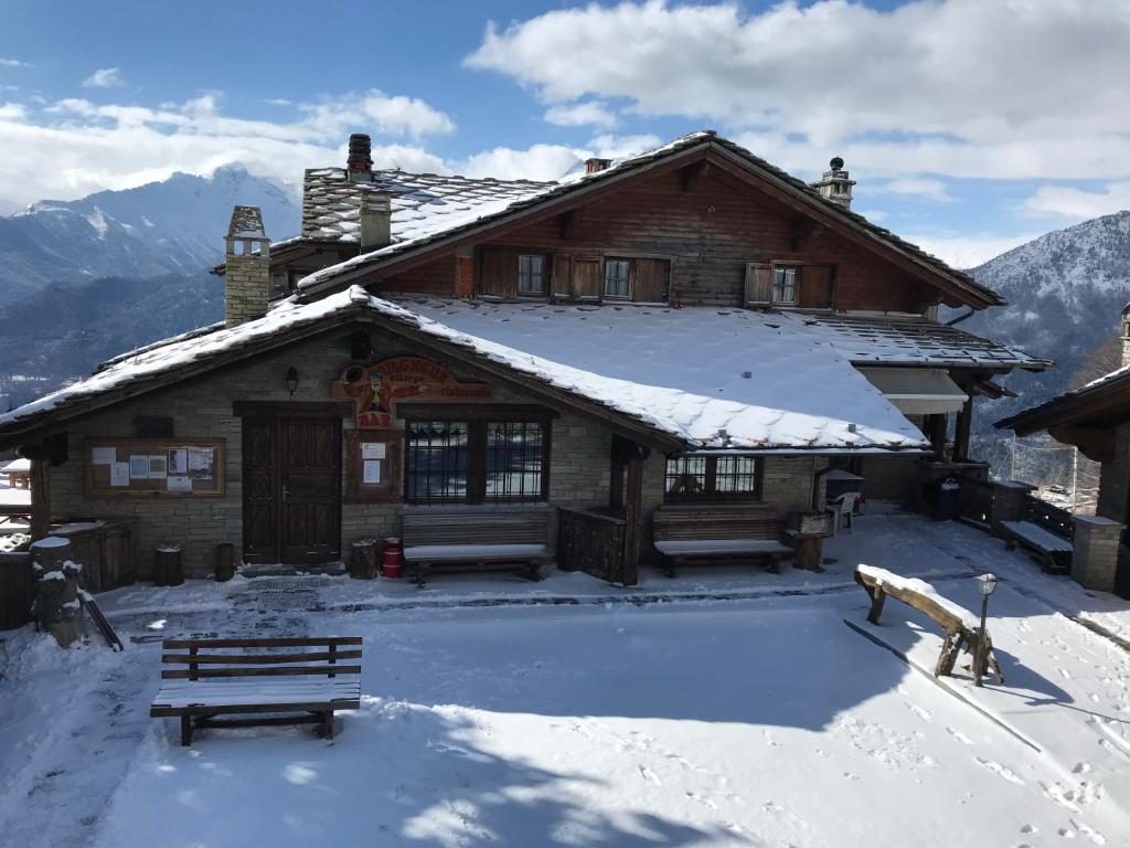 eine Blockhütte mit Schnee auf dem Dach in der Unterkunft Hotel Ristoro Vagneur in Saint Nicolas