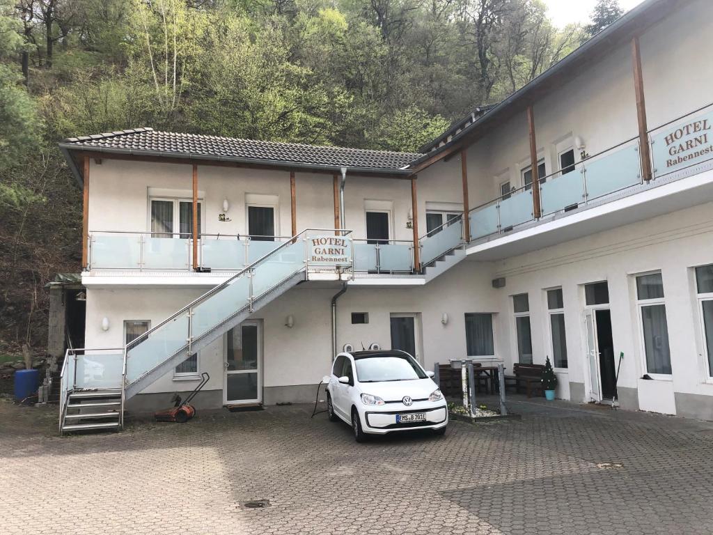 a car parked in a parking lot in front of a building at Hotel Garni Rabennest in Braubach