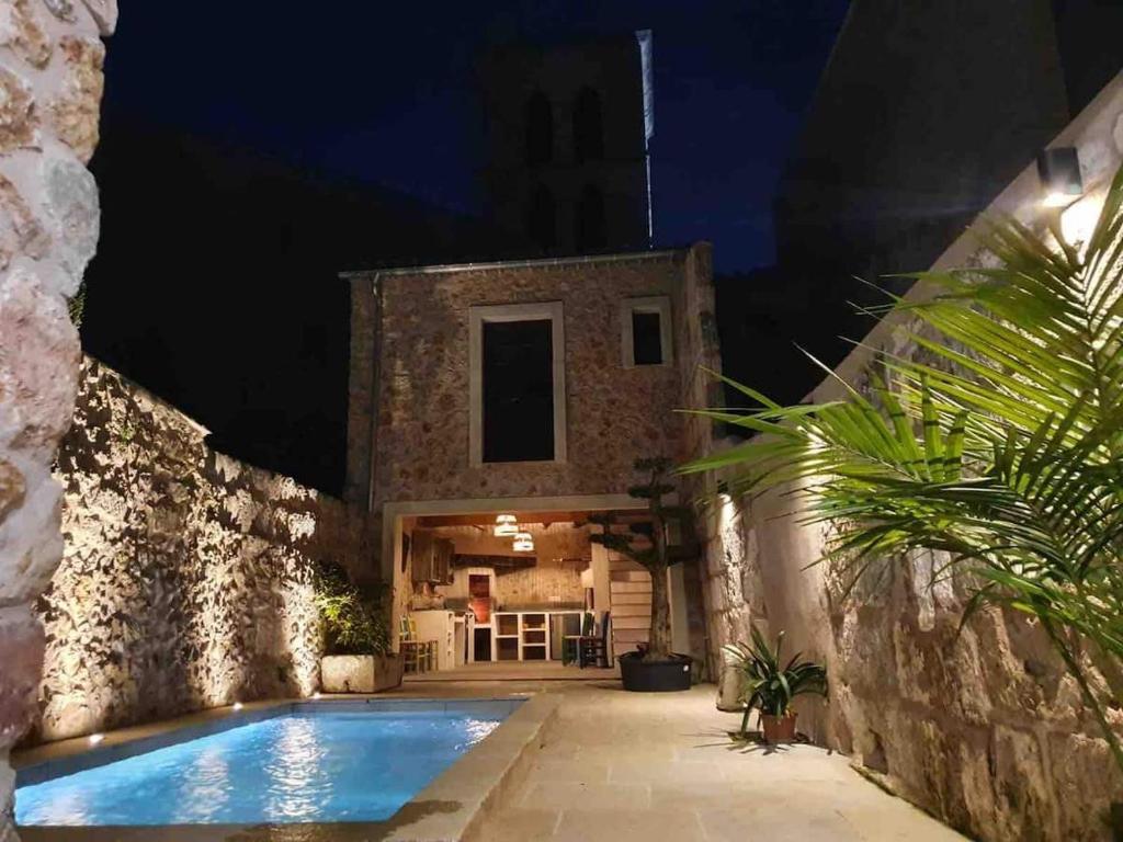 a house with a swimming pool at night at Town House Ca Na Mabel in Sa Pobla in Sa Pobla