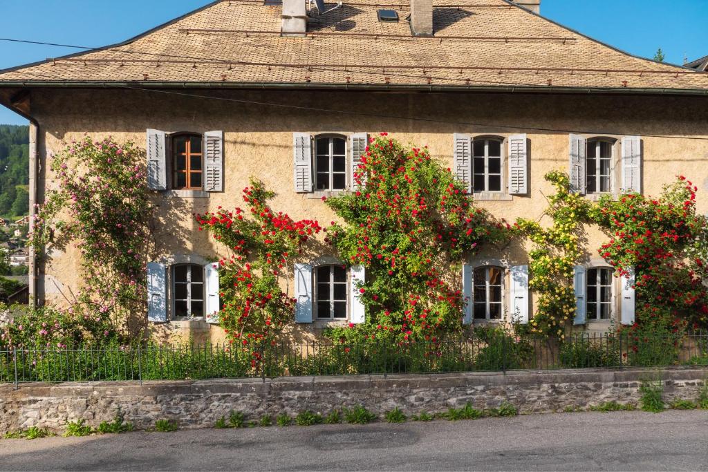 un bâtiment avec des fleurs rouges sur son côté dans l'établissement The Manoir, à Morzine