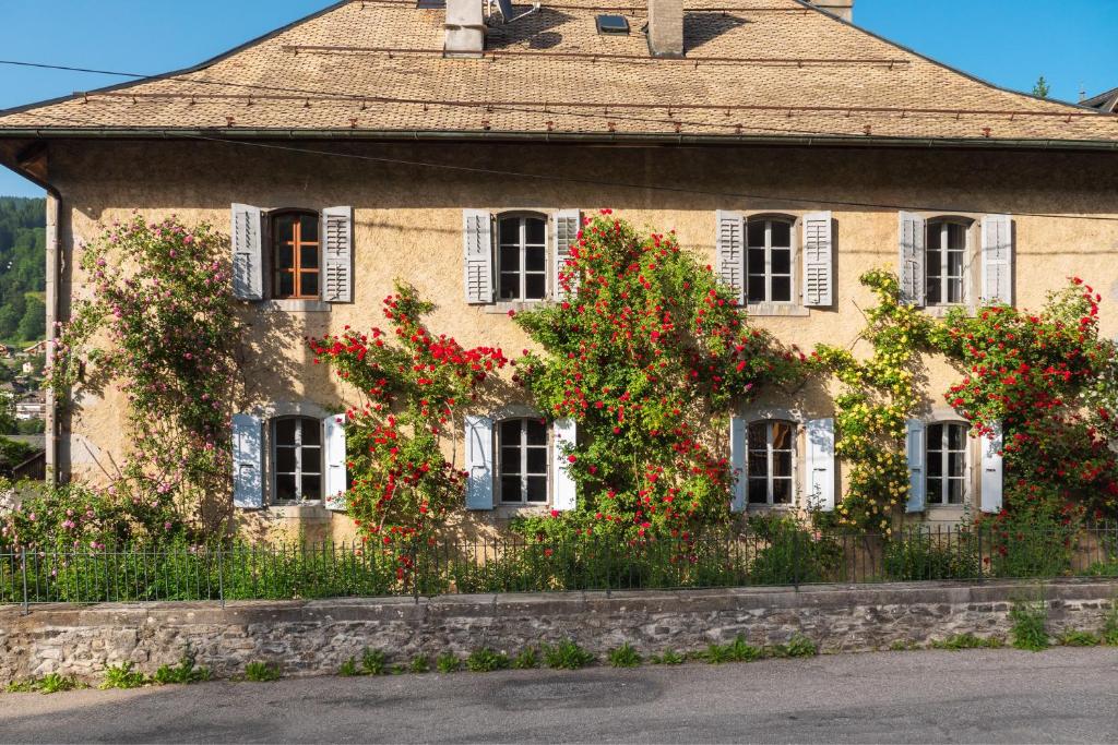 un edificio con flores rojas a un lado. en The Manoir, en Morzine