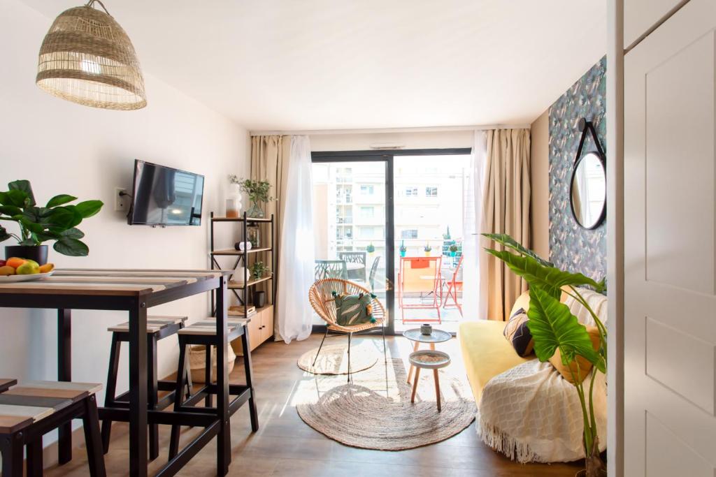 un salon avec une table et une salle à manger dans l'établissement C1 Clemenceau Pool Balcony Bath AC 2mins walk to sand beach, à Cannes