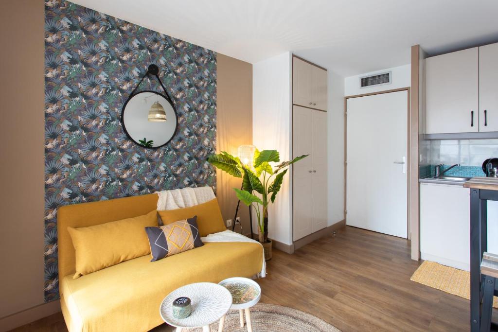 sala de estar con sofá amarillo y pared en C1 Clemenceau Pool Balcony Bath AC 2mins walk to sand beach, en Cannes