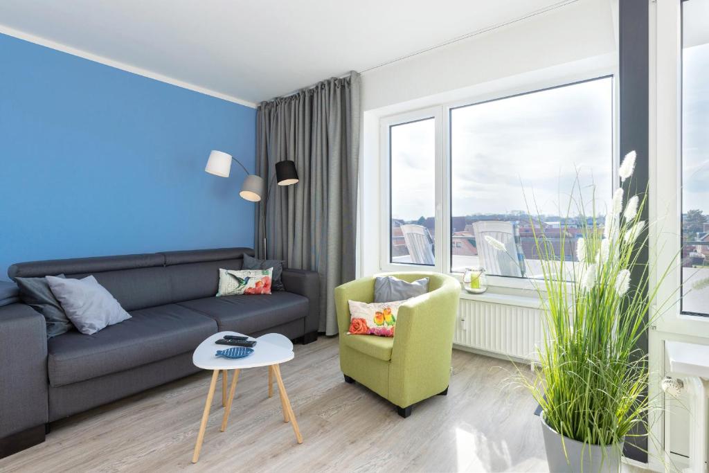 a living room with a couch and a chair and a window at Haus Seebad Aussicht in Grömitz