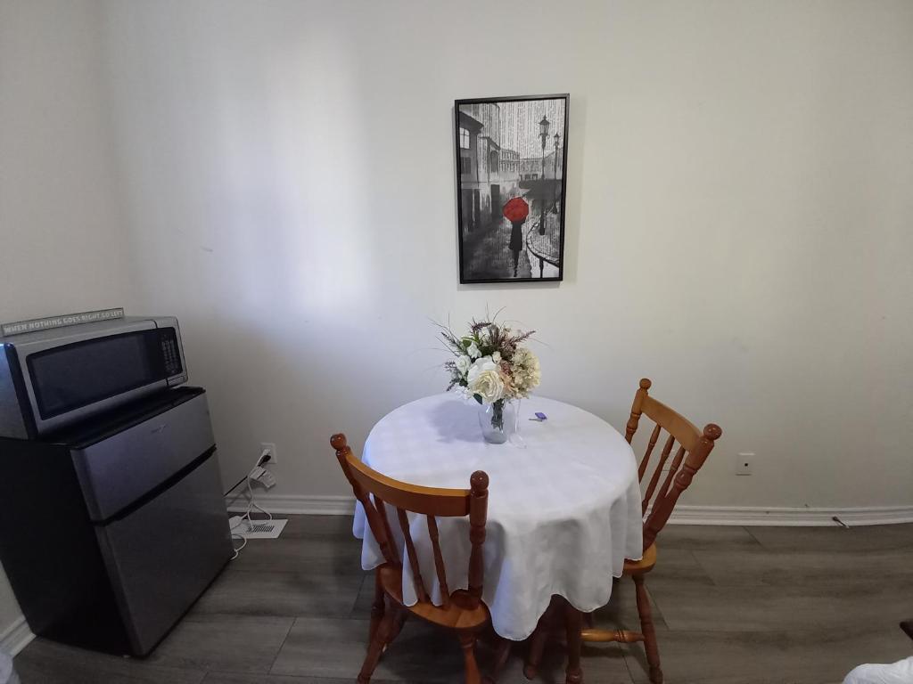a dining room table with a vase of flowers on it at May Flowers in Kingston