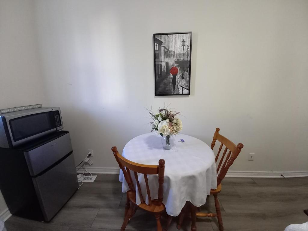 a dining room table with a vase of flowers on it at Main Suite in Kingston