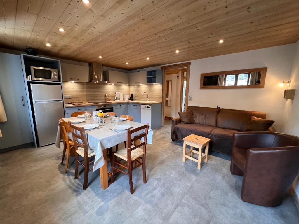 une cuisine et un salon avec une table et un canapé dans l'établissement Gentianes 4 - Appartement centre village, à La Clusaz