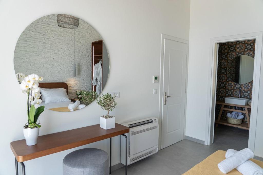 biała łazienka z umywalką i lustrem w obiekcie White Blossoms Villas w mieście Trapezaki