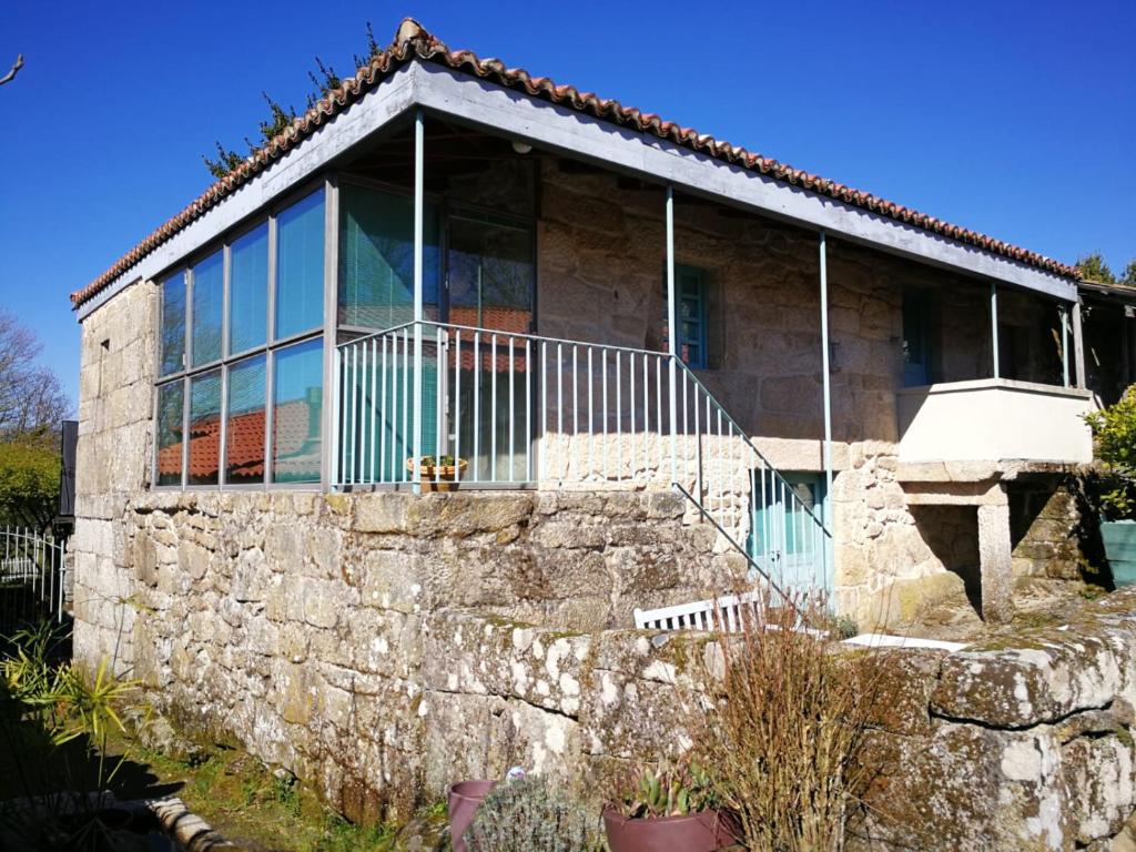 una casa in pietra con un muro di pietra di Casa A Canella a Sobreira