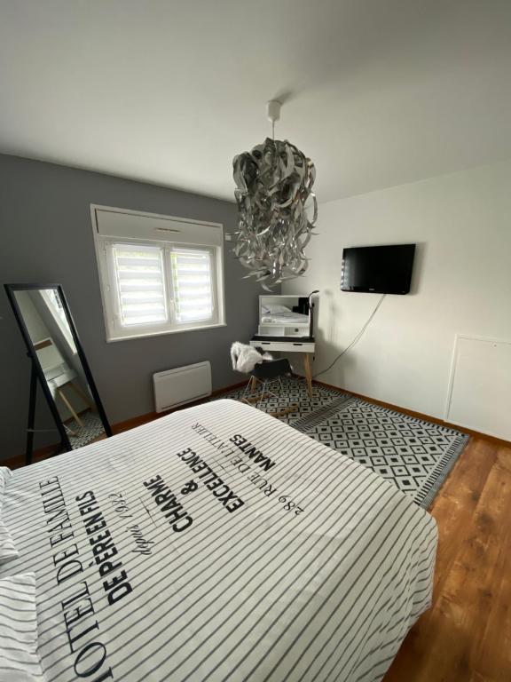 Schlafzimmer mit einem Bett und einem Kronleuchter in der Unterkunft Maison moderne à la campagne in Le Valdahon