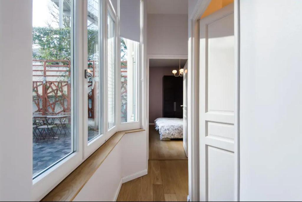 a hallway with large windows and a room with a bed at VIEUX LILLE Porte de Gand Bienvenue chez NESTYOU, Lille in Lille