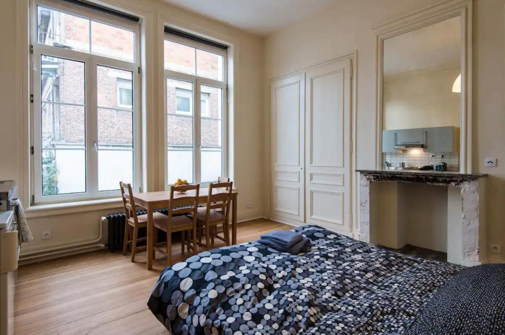 a bedroom with a bed and a table and chairs at VIEUX LILLE Porte de Gand Bienvenue chez NESTYOU, Lille in Lille