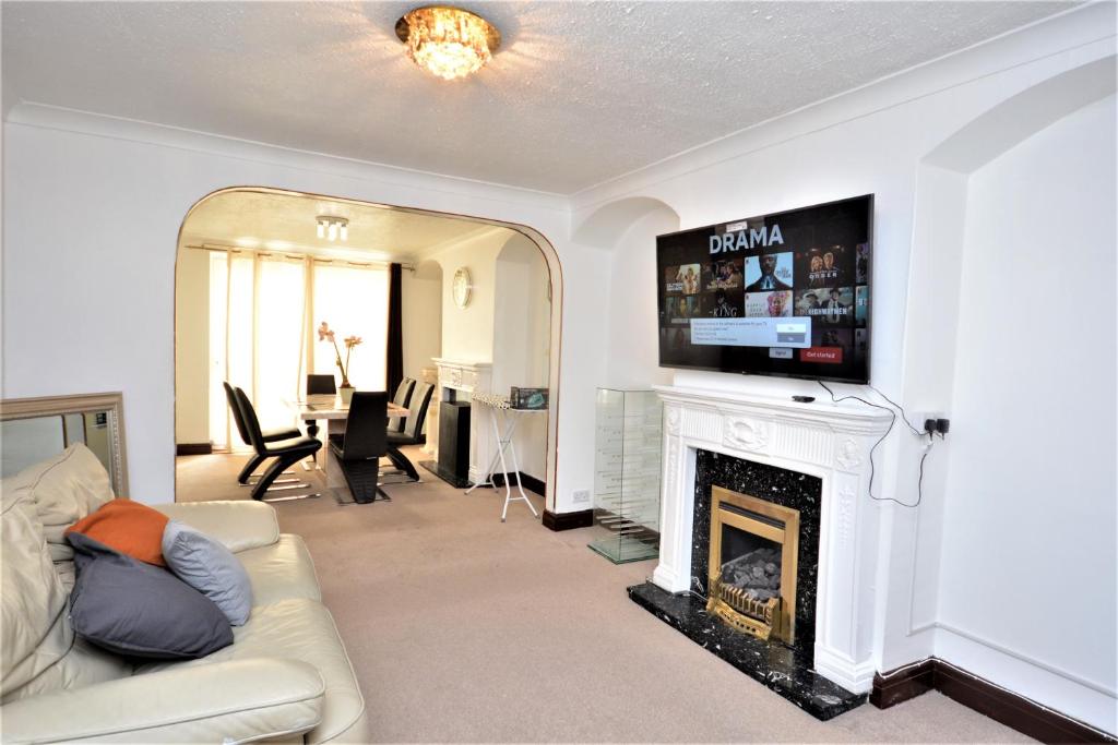 a living room with a couch and a fireplace at London Deluxe 3 Bedroom House with parking space in Dagenham