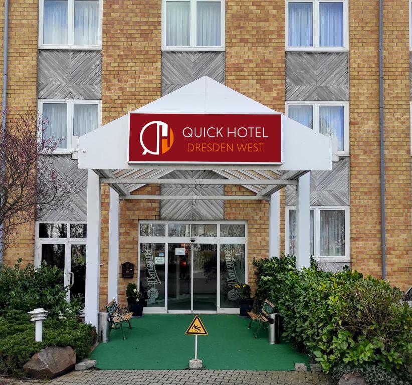 un cartello veloce per la digestione ovest di un hotel di fronte a un edificio di Quick Hotel Dresden West a Kesselsdorf