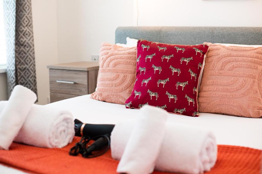 Una cama con almohadas rosas y rosas. en Byng! This one's for you - TV in Every Bedroom!, en Morriston