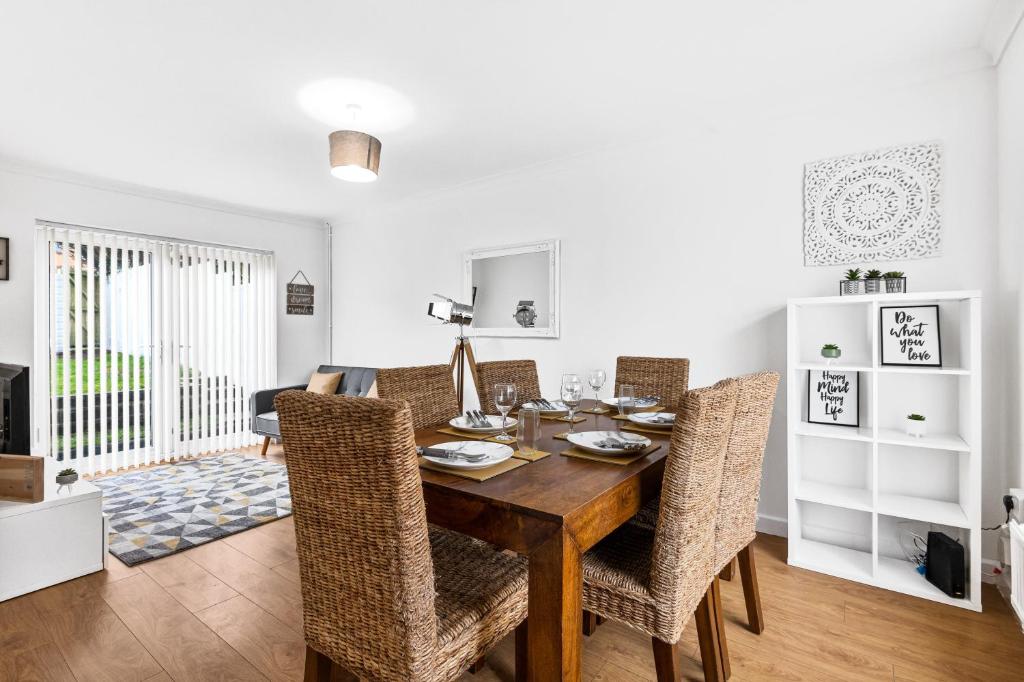 a dining room with a wooden table and chairs at Clase Accommodation - TV in Every Bedroom! in Morriston