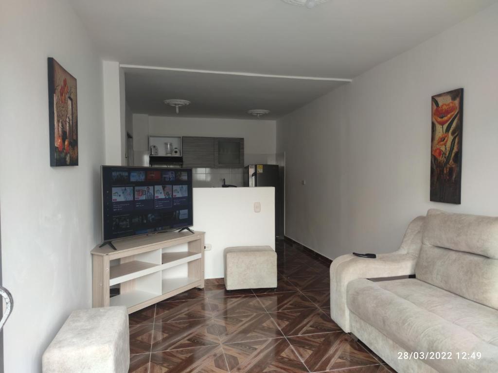 sala de estar con sofá y TV en Hermoso apartaestudio, en Pitalito
