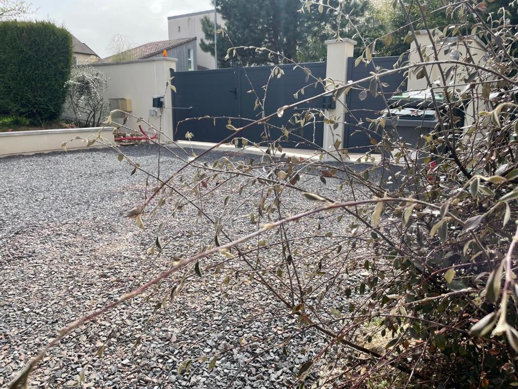 a gravel yard with a fence and a house at Le boudoir in Épinal