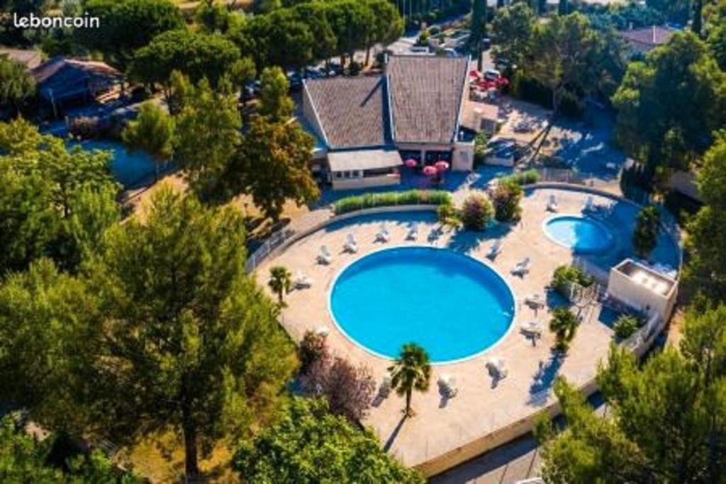 an overhead view of a swimming pool with chairs and trees at La Roque d'Anthéron - Mobile-home - 6 pers - 3 ch - Piscine in La Roque-dʼAnthéron