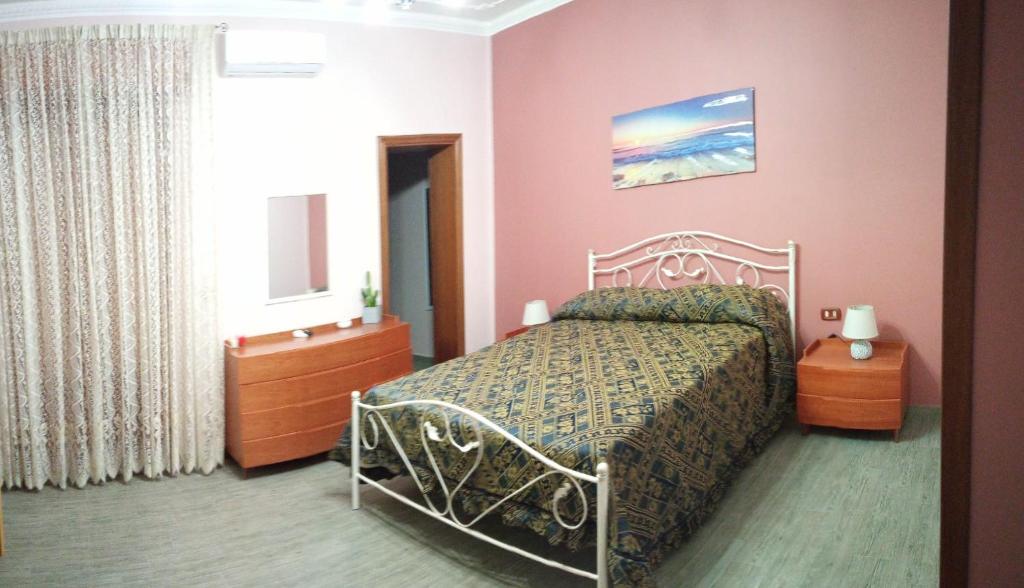 um quarto com uma cama num quarto cor-de-rosa em SoleLuna 319 em Reggio di Calabria