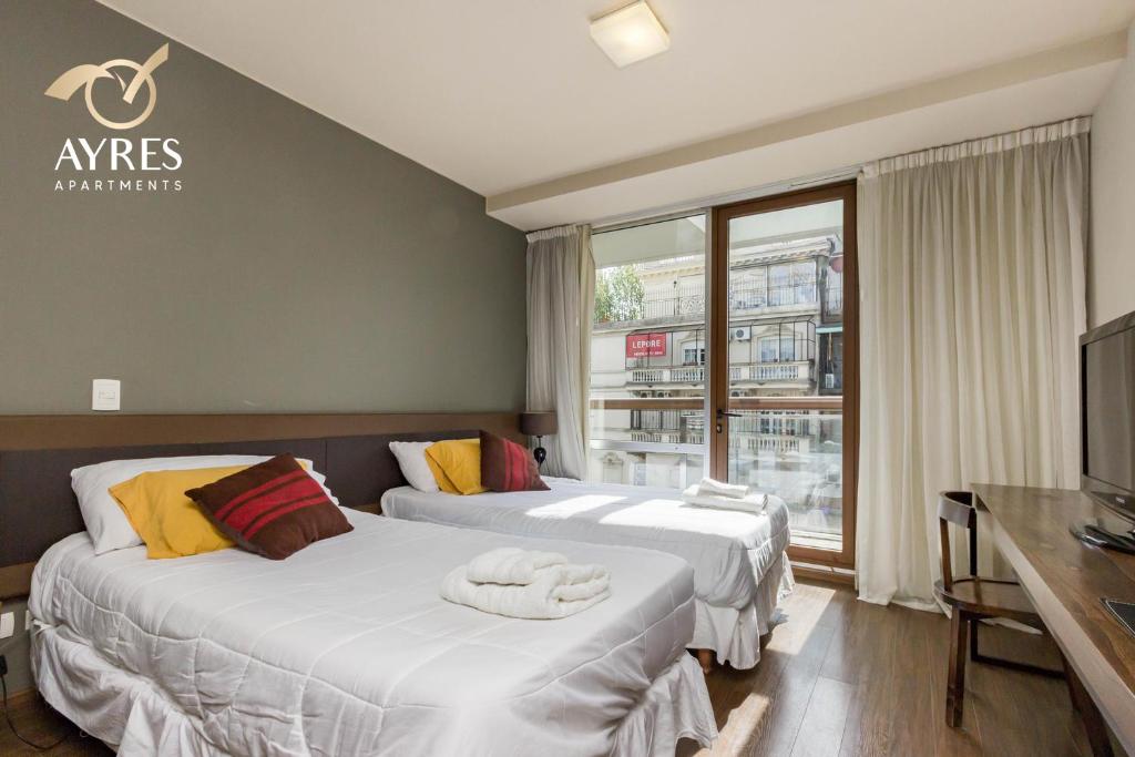 Habitación de hotel con 2 camas y TV en Ayres Apartments Palermo en Buenos Aires