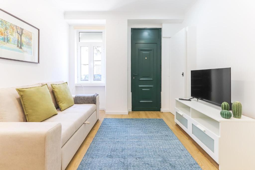 a living room with a couch and a tv at Vita Portucale ! Stylish Apartment Campo Ourique in Lisbon