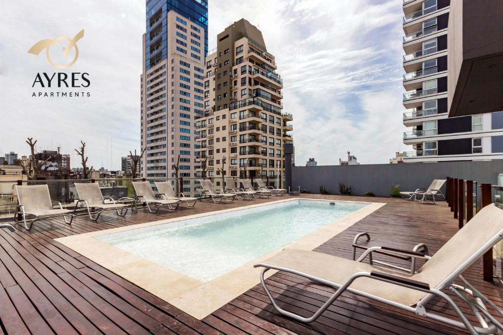 ブエノスアイレスにあるAyres Apartments Palermoのデッキ(椅子、建物付)のスイミングプール