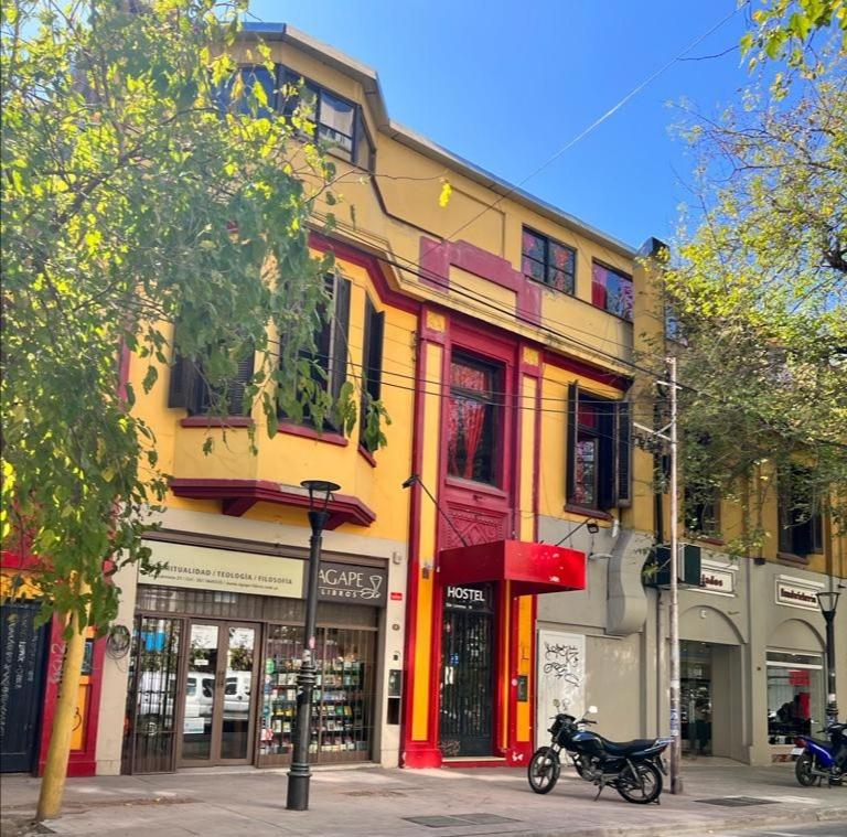 a yellow and red building on a city street at Katana Capsule Hostel in Mendoza