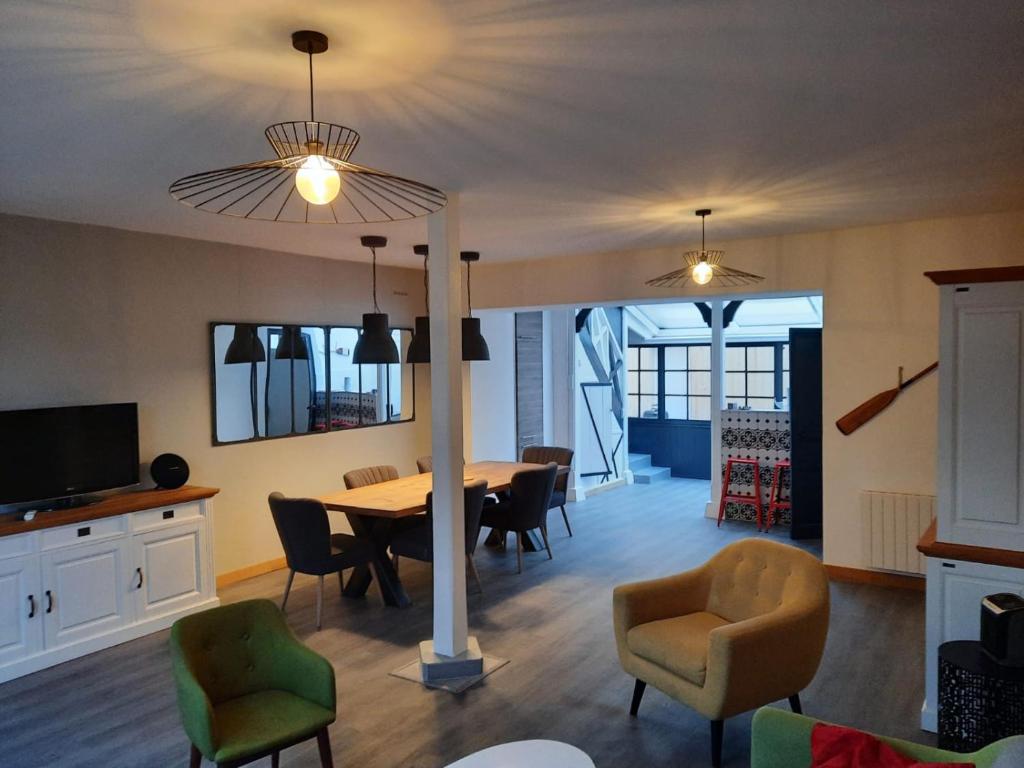 Villa LES MYRTILLES في كابورغ: غرفة طعام مع طاولة وكراسي