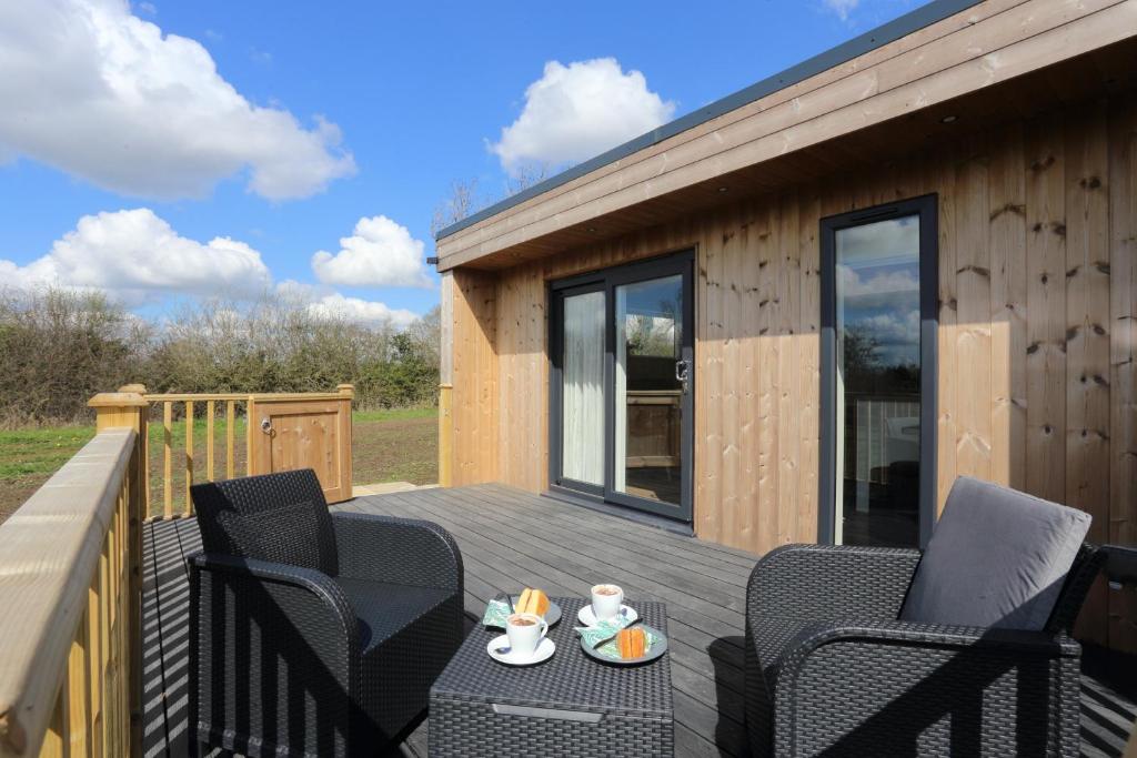 a deck with chairs and a table on a house at The Swift in Whitchurch