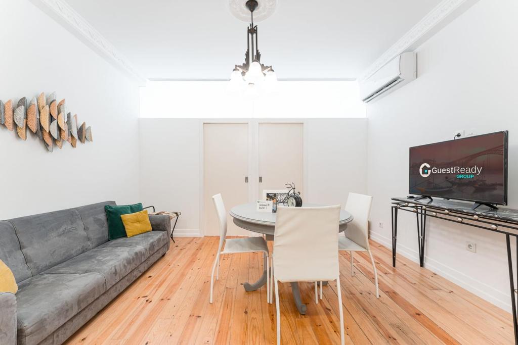 a living room with a couch and a table with chairs at GuestReady - Gold Leaf 2F in Porto