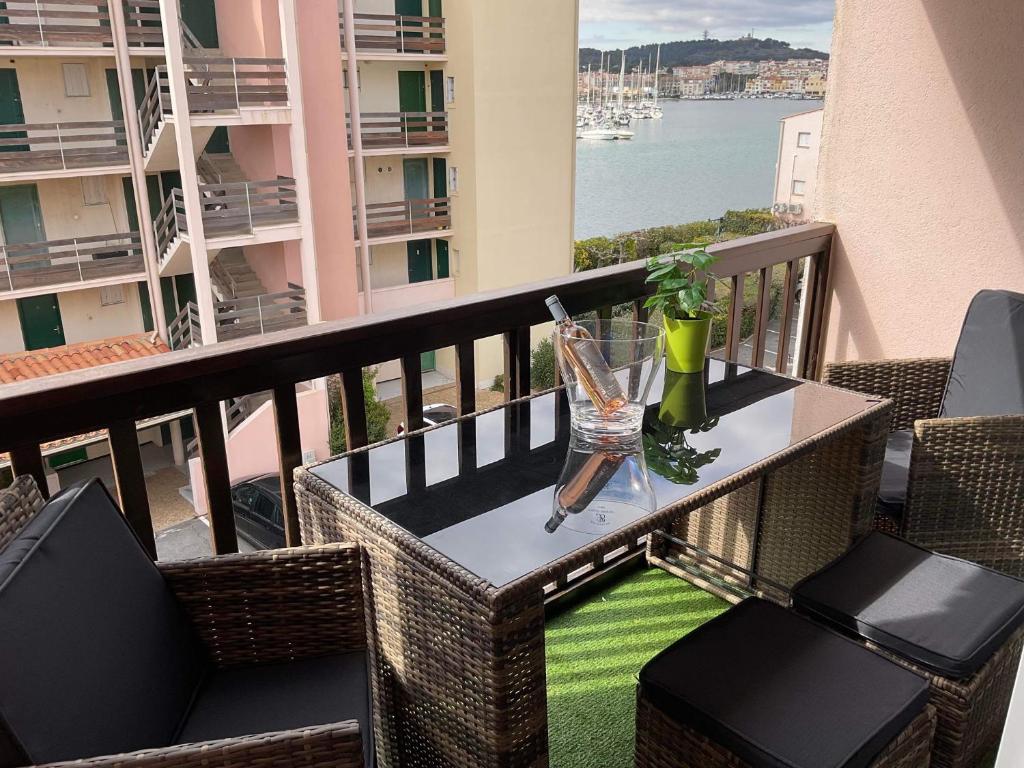 une table et des chaises sur un balcon avec vue sur l'eau dans l'établissement Studio Cap Agde, au Cap d'Agde
