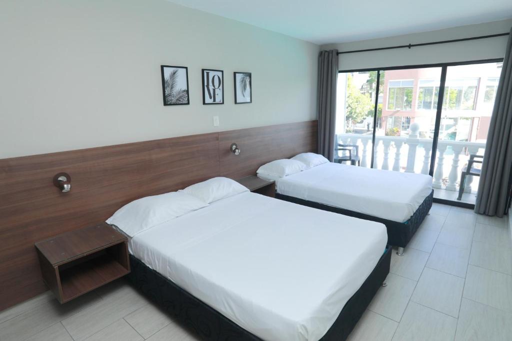 Postel nebo postele na pokoji v ubytování HOTEL MELGAR PLAZA