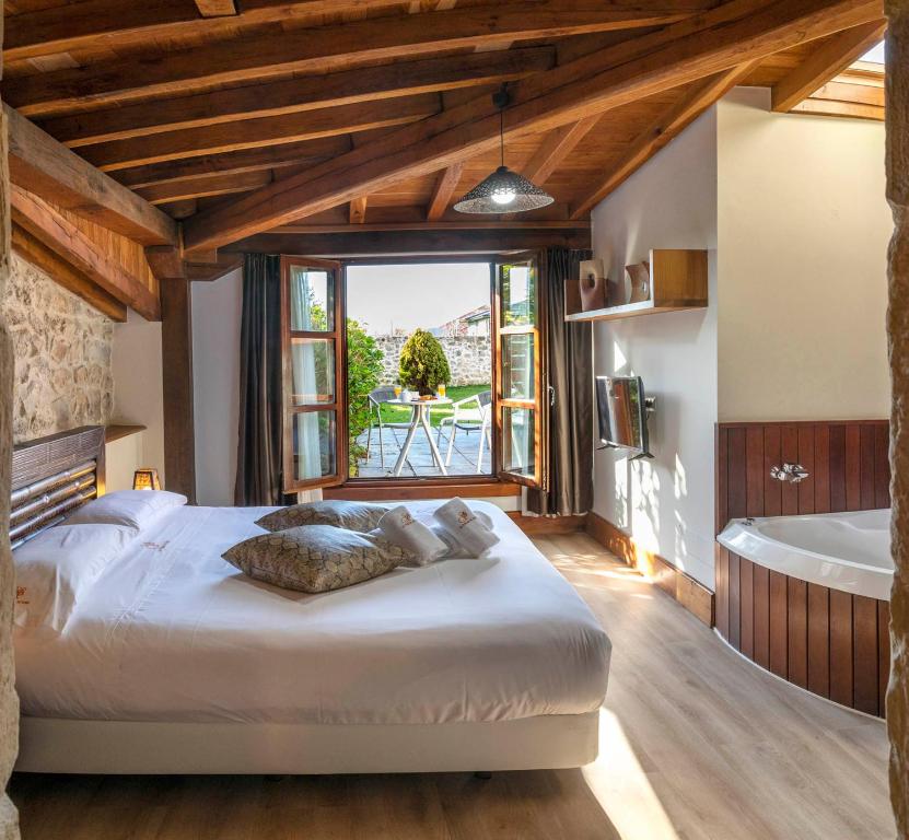 a bedroom with a large bed and a bath tub at Don Pablo Playa de Somo in Somo