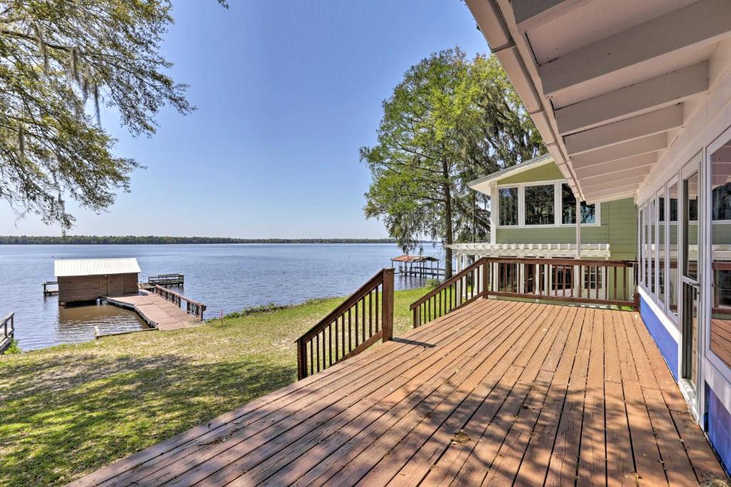 a house with a wooden deck next to the water at Peaceful Escape with Boat Dock on Lake Talquin! in Quincy