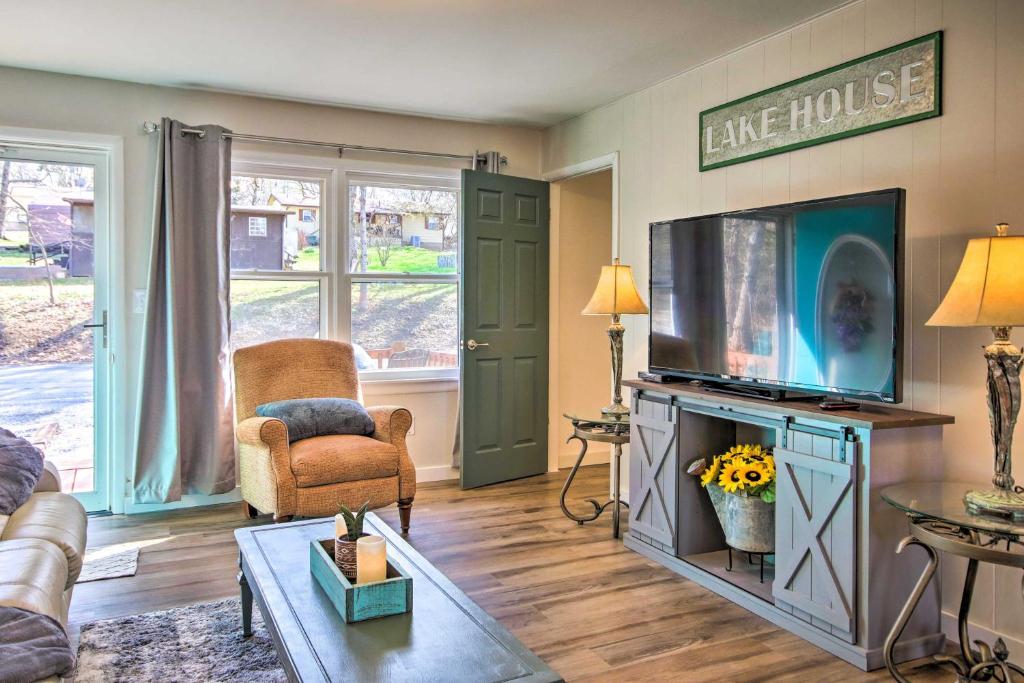 ein Wohnzimmer mit einem TV und einem Sofa in der Unterkunft Lakefront Gem with Screened Porch and Game Room! in Shell Knob