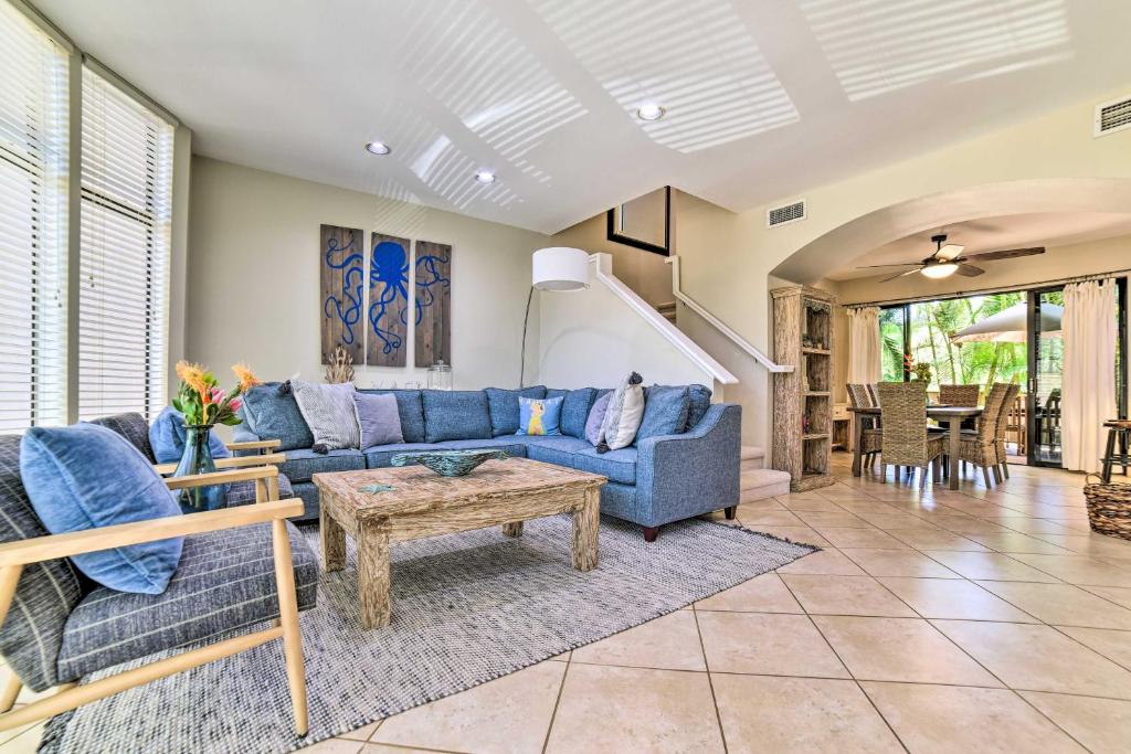 a living room with a blue couch and a table at Bright and Airy Lahaina Condo - Walk to Beach! in Kahana