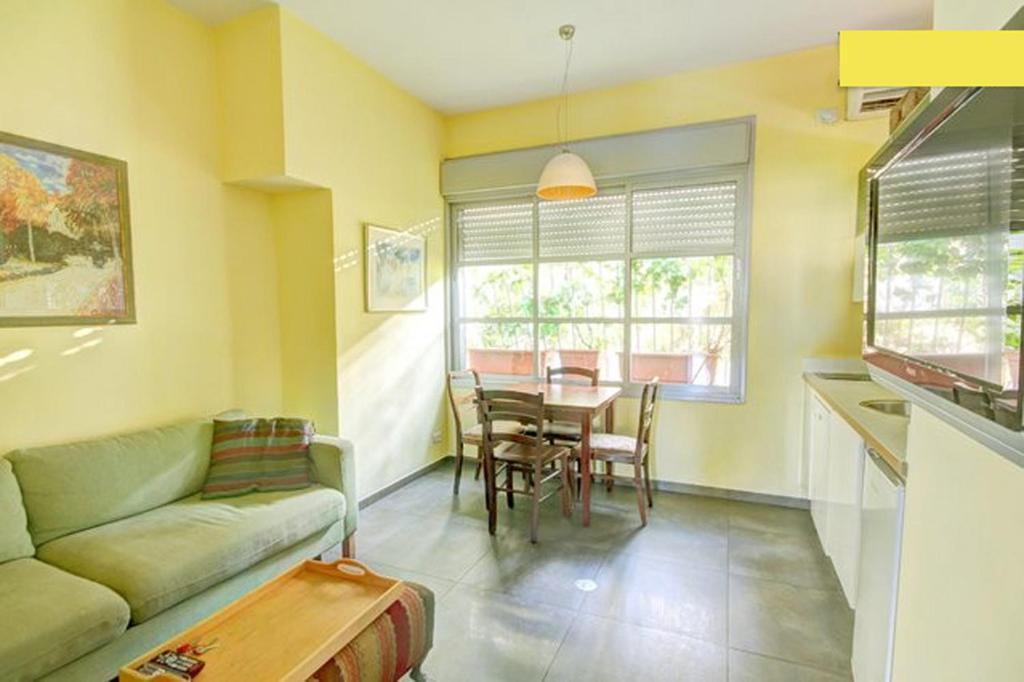 テルアビブにあるTLV Living Apartmentのソファとテーブルのあるリビングルーム