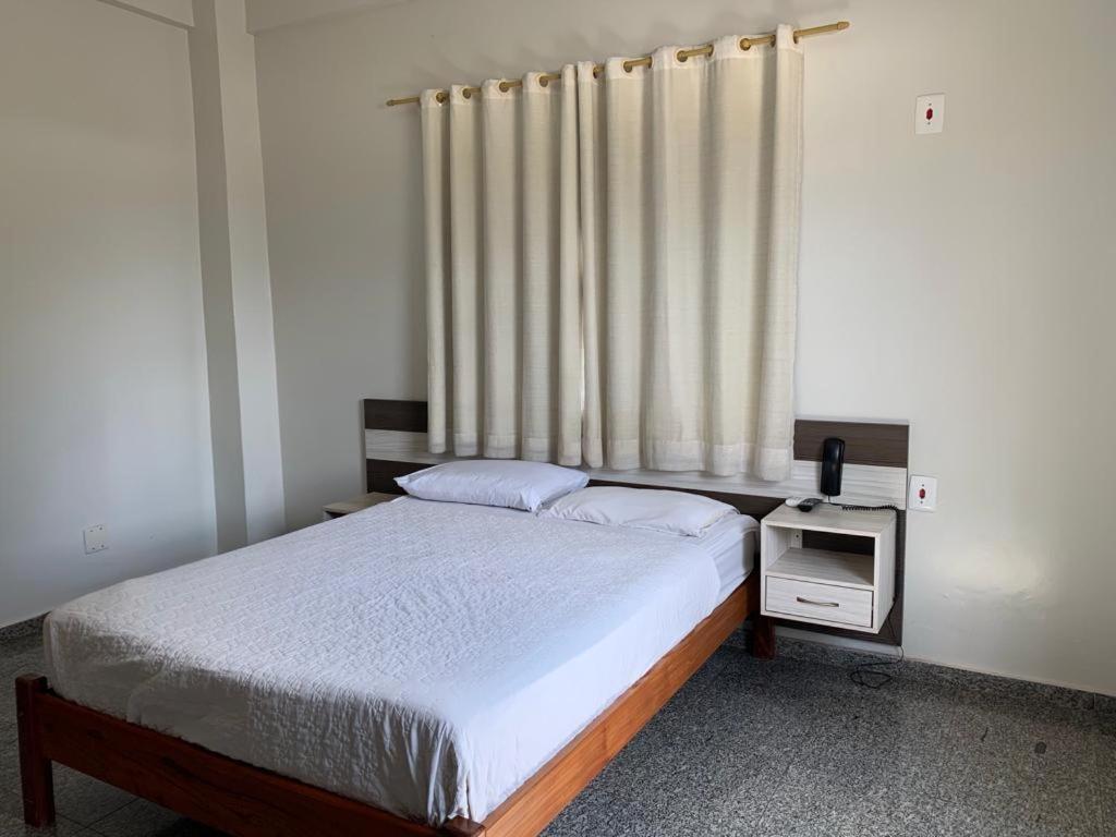 a bedroom with a bed and a window with curtains at HOTEL QUALITY in Parauapebas