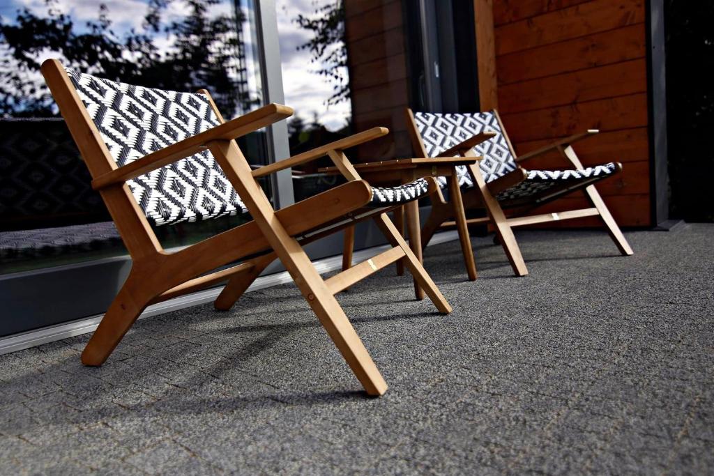 ein paar Stühle auf einer Veranda in der Unterkunft Noclegi LIW APARTMENTS Hotel Apartamenty in Węgrów