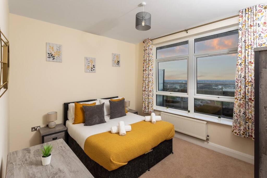 a bedroom with a bed and a large window at Ashford Penthouse Apartment near town with free parking, linens & towels great for contractors or families in Ashford