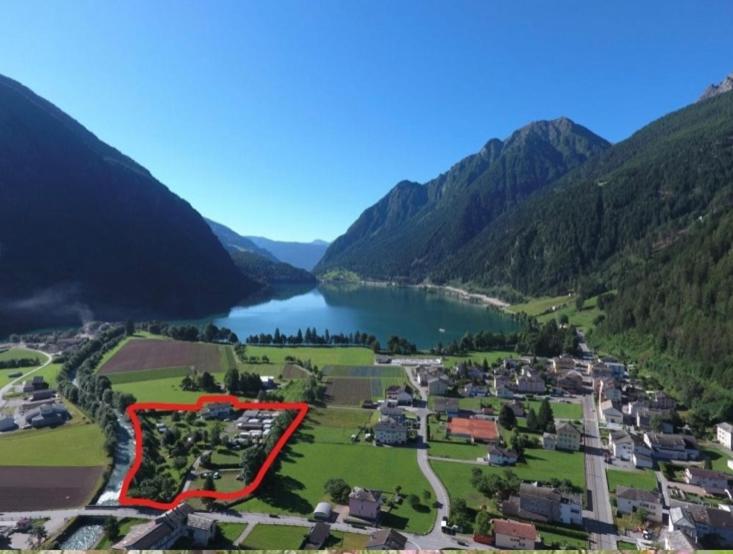 an aerial view of a village next to a lake at Bungalow Miralago in Camping Cavresc, Via dal Cavresc 1, 7746 Le Prese-Poschiavo in Poschiavo