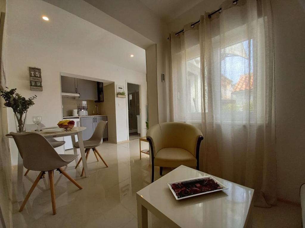 een woonkamer met een tafel en stoelen en een keuken bij Apartmani Alma in Pula