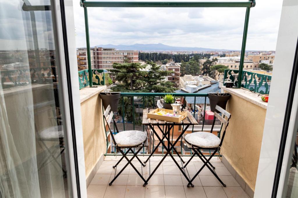 a balcony with a table and chairs and a view at SAPIENZA Apartment in Rome