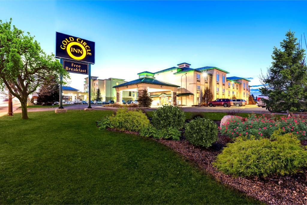 ein Hotelschild vor einem Hof mit Blumen in der Unterkunft Gold Circle Inn in Lloydminster