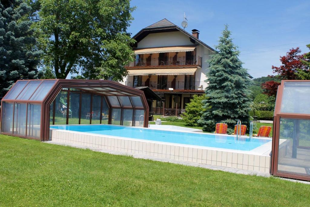 a house with a swimming pool in front of a house at Pension Sommerauer in Hallein