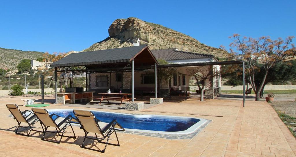 a group of chairs sitting next to a swimming pool at Villa Ismael by Rental Olé in Crevillente