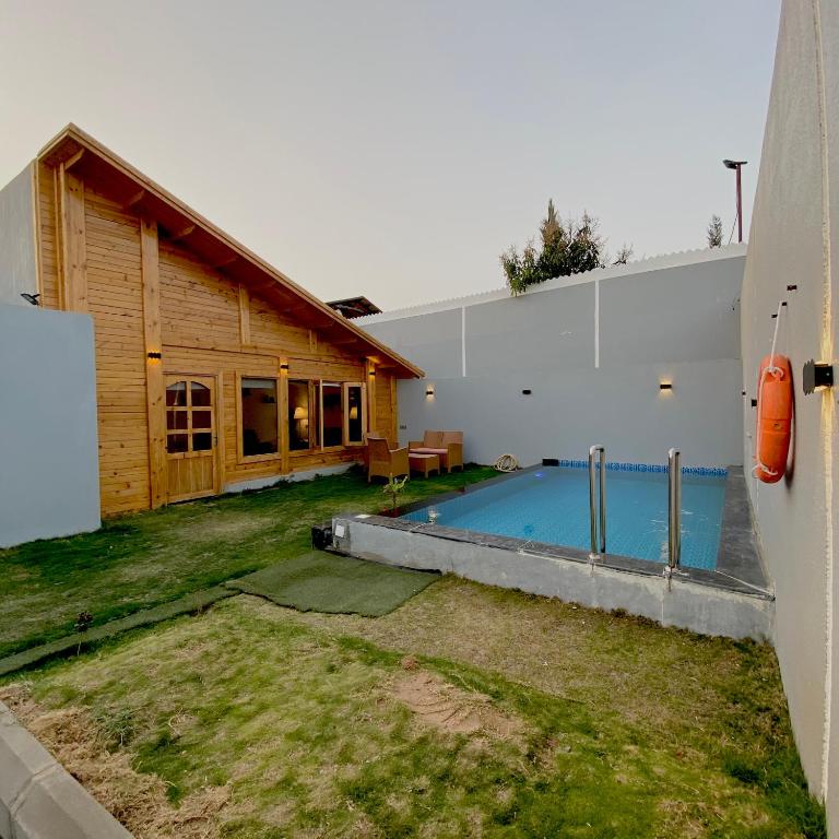 a house with a swimming pool next to a building at منتجع نون الفندقي in As Sayl aş Şaghīr