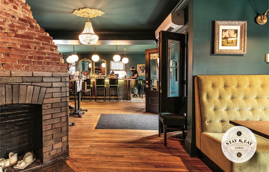 a room with a brick fireplace and a bar at Slaymaker & Nichols Gastro House & Inn in Charlottetown
