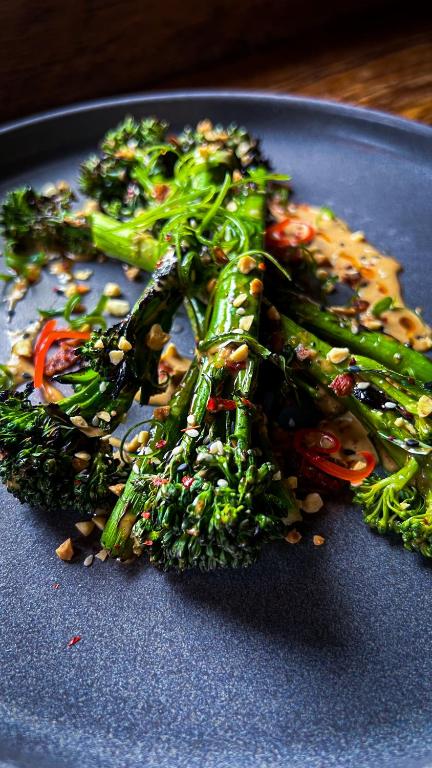a blue plate of food with broccoli and vegetables at Slaymaker & Nichols Gastro House & Inn in Charlottetown